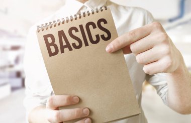 Kahverengi kâğıt not defterine BASICS 'i mesaj at. İşadamlarının ellerinde. İş konsepti