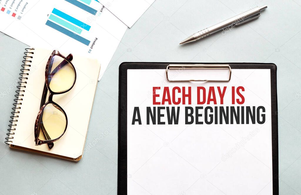 Business concept. Notebook with text Each day is a new beginning sheet of white paper for notes, glasses in the white background