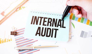 İş adamı eli, kağıt tabak, kalem, diyagram, çizelge ve ofis aletleri. Metinler İçler Arası Uygulama