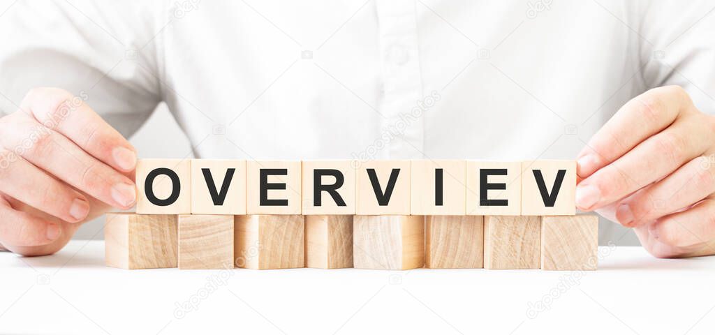 Businessman holding wooden block. Businessman watch on the wooden cubes with text overview. financial market. financing