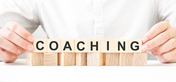 Бизнесмен держит деревянный блок. Бизнесмен смотрит на деревянные кубики с текстом УЧАСТНИК. финансового рынка. финансирование