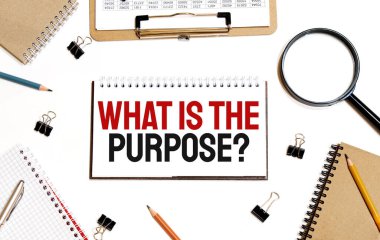 İş konsepti. Not defteri beyaz arka planda notlar, hesap makinesi, gözlük, kalem, kalem için beyaz kağıdın PURPOSE sayfası nedir