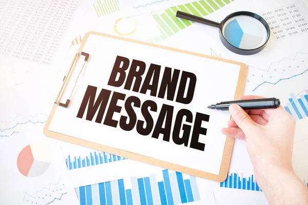 Text BRAND MESSAGE on white paper sheet and marker on businessman hand on the diagram. Business concept