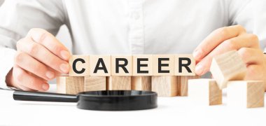 Elinde tahta küpler tutan bir iş adamı. İşadamı, tahta küpleri CAREER mesajıyla izliyor. Finansal. finansman