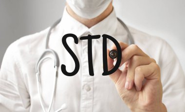 Doktor keçeli kalemle STD yazıyor. Tıbbi konsept.