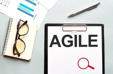 İş konsepti. Not defteri notlar için AGILE beyaz sayfa, beyaz arkaplan için gözlük