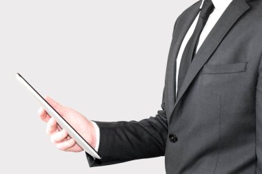 İş adamı ofisteki bir tablette kitap okuyor.