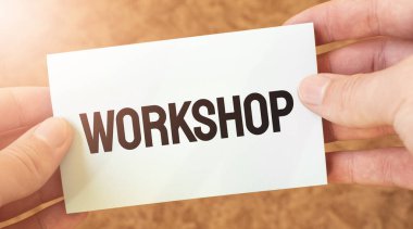 Bir işadamının elindeki beyaz kart kağıdına işyeri kelimesi yazılıydı. Özet konsepti. kırmızı ve beyaz kağıt