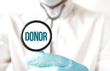 Doktor elinde steteskop tutuyor, DONOR yazılı, tıbbi konsept.