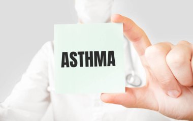 Doktor elinde kart tutuyor ve ASTHMA kelimesini işaret ediyor.