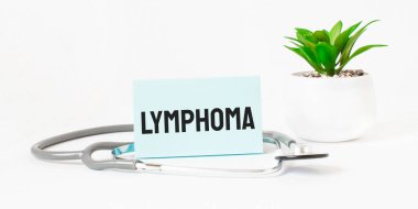 Not defteri, steteskop ve yeşil bitki üzerine LYMPHOMA kelimesi