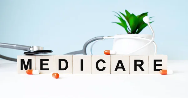 MEDICARE kelimesi ahşap bir arka planda steteskopun yanındaki tahta küplere yazılmıştır. Tıbbi konsept