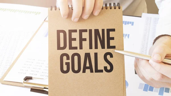 Tekst Define Goals Brązowym Papierze Notatnik Rękach Biznesmena Stole Diagramem — Zdjęcie stockowe