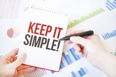 Notepad with text KEEP IT SIMPLE. Diagram and white background