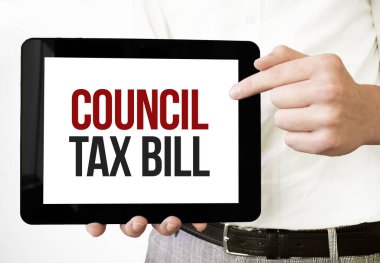 Text coUNCIL TAX BILL on tablet display in businessman hands on the white bakcground. Business concept