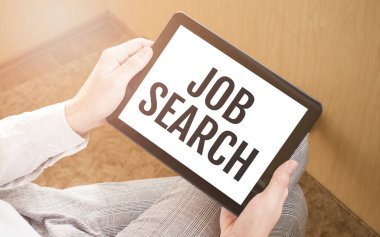 Dijital tablet kullanan bir adam, yakın plan, arka planda kahve ve klavye. Metin Araması