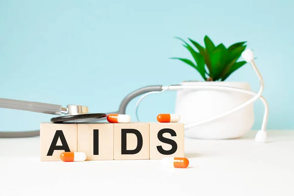 Aidsという単語は木製の背景の聴診器の近くの木製の立方体に書かれている 医学的概念 — ストック写真