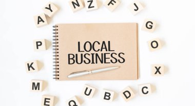 Beyaz zemin üzerinde blok tahta küpleri ile zanaat renkli not defteri üzerine yerel metin iş