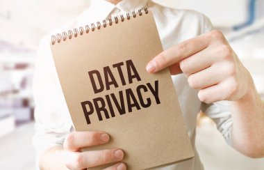 Ofisteki işadamlarının elindeki kahverengi kağıt not defterine metin veri gizliliği. İş konsepti