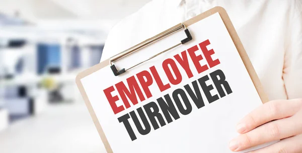 Ofisteki işadamlarının elindeki beyaz kağıt tabakta EMPLOYEE TURNOVER 'a mesaj at. İş konsepti