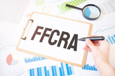 Beyaz kağıt üzerinde FFCRA ve diyagramda da işadamı eli üzerinde işaretleyici yaz. İş konsepti
