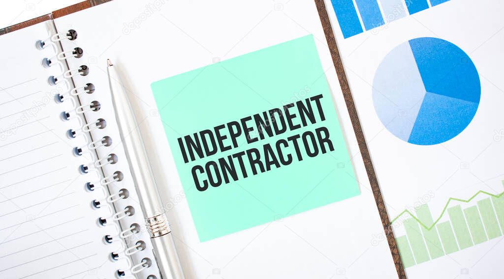 Green card on the white notepad. Text independent contractor. Business concept