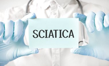 Doktor elinde kart tutuyor ve SCIATICA kelimesini işaret ediyor.