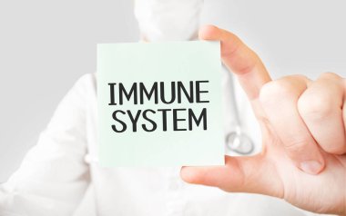 Doktor elinde kart tutuyor ve bağışıklık sistemini işaret ediyor.