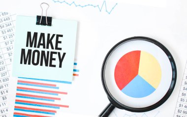 Beyaz not defterinde yeşil kart ve finansal belgelerde büyüteç. Metin para kazandırır. İş konsepti