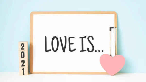 爱情是文字和2021立方体与红心形装饰蓝色木制桌子的背景 快乐情人节的理念 — 图库照片