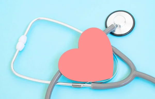 Health care check-up with red heart and Stethoscope on a blue background. Healing care concept and copy space. Above view of medical equipment for disease treatment on the blue backdrop.