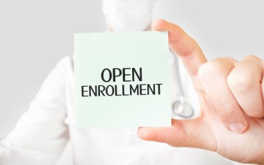 Doktor elinde kart tutuyor ve açık kayıt kelimesine işaret ediyor.