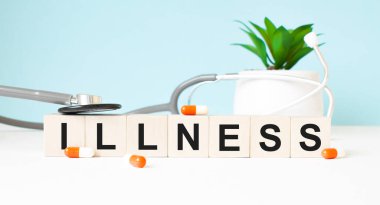 Hastalık kelimesi ahşap bir arka planda steteskopun yanındaki tahta küplere yazılır. Tıbbi konsept