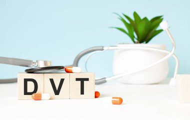 Dvt sözcüğü ahşap bir arka planda steteskopun yanındaki tahta küplere yazılır. Tıbbi konsept