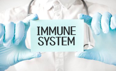 Doktor elinde kart tutuyor ve bağışıklık sistemini işaret ediyor.