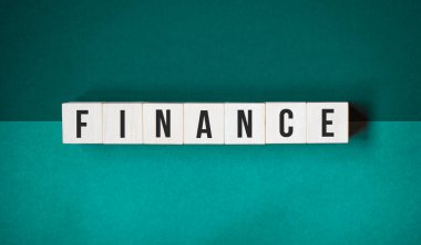 Tahta küplerin finansmanı. Yatırım ve tasarruf parası kavramı. Turuncu arkaplanda harf bulunan tahta bloklar..