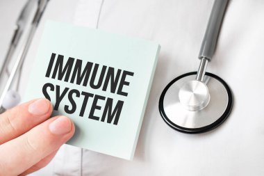 Doktor elinde kart tutuyor ve bağışıklık sistemini işaret ediyor.