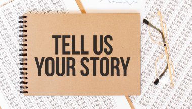 Yazılı renkli not defteri bize hikayeni anlat. Gözlüklü ve metin belgeli not defteri. İş konsepti