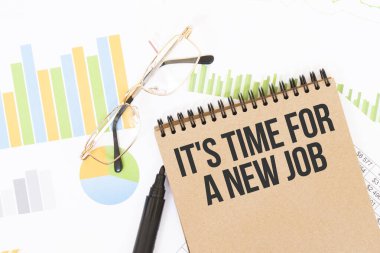 El işi renkli bir defterde, yeni bir iş için, kalemlerin, gözlüklerin, grafiklerin ve diyagramların yanında bir IT 's Time vardır..