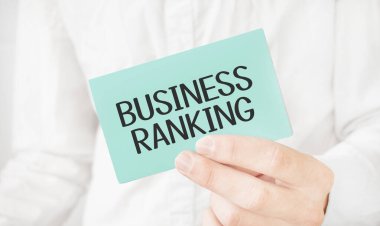 Beyaz tişörtlü bir iş adamı elinde metin işi sıralaması olan yeşil bir kart tutuyor.