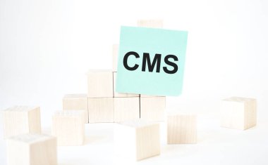 Yeşil kart kübü merdiveni ile yazılan CMS metni. Beyaz arka plan. İş konsepti