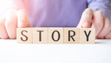 İş adamının elinde tahta küp bloğu var. Masa arkasında da iş dünyası kelimesi var. Görev, Vizyon ve temel değerler kavramı