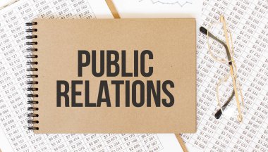 Metin Halkla İlişkiler ile birlikte el işi renkli not defteri. Gözlüklü ve metin belgeli not defteri. İş konsepti