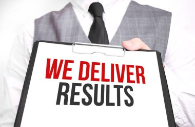 Elinde bir kâğıt tutmakta olan iş adamı. Sonuçları ilettik.