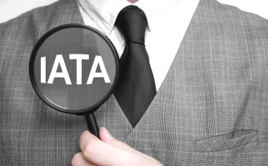 Beyaz arka planda büyüteç olan bir iş adamı. IATA işareti