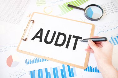 Beyaz kağıt üzerinde denetim metni ve diyagramda da işadamı eli üzerinde işaret. İş konsepti