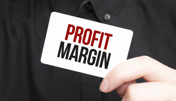 Businessman holding a card with text PROFIT MARGIN,business concept