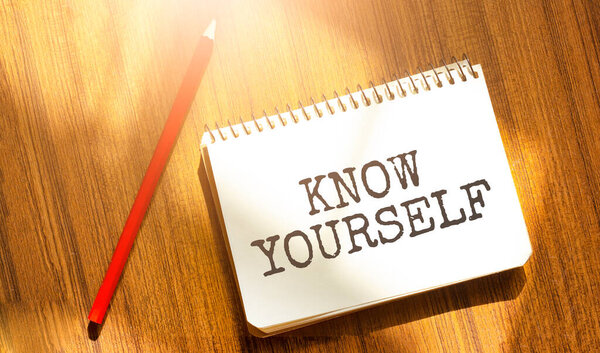 ноутбук и ручка на деревянном столе, место для копирования текста, надпись ЗНАЙТЕ себя на скомканной желтой бумаге, рабочем месте, мозговой штурм