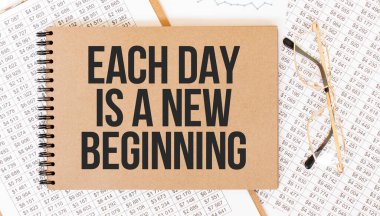 Yazılı renkli not defteri her gün yeni bir başlangıçtır. Gözlüklü ve metin belgeli not defteri. İş konsepti