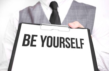 Elinde bir kağıt tutmakta olan bir iş adamı. Kendin ol.